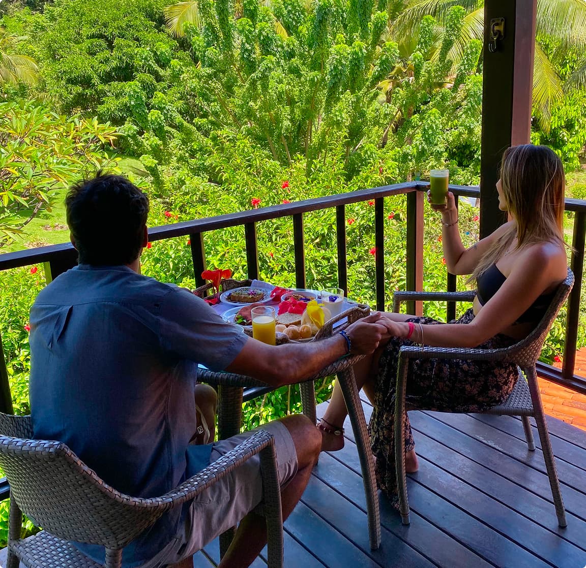 Casal toma café da manhã na varanda da suíte com vista para o Jardim Elizabeth