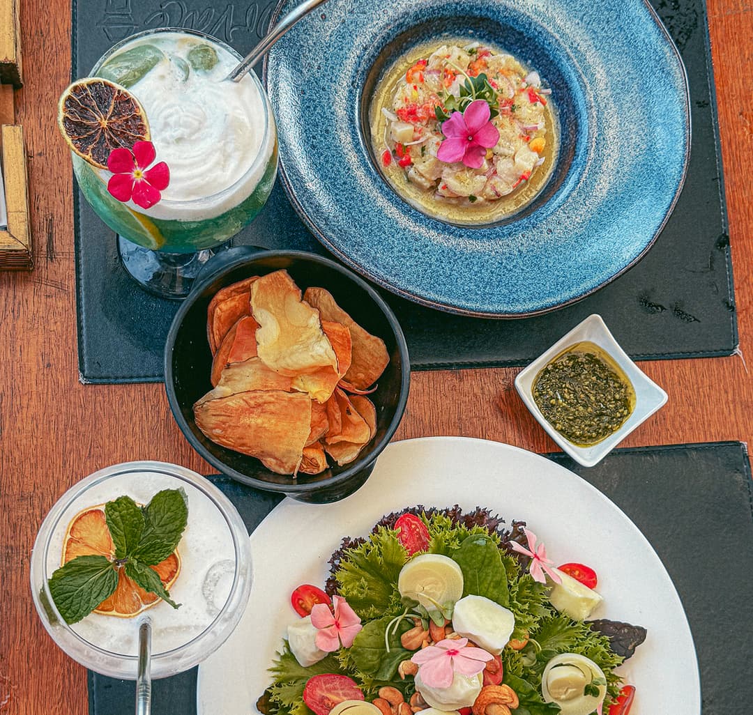 Mesa com pratos artesanais e drinks do Restaurante do Vale em Noronha